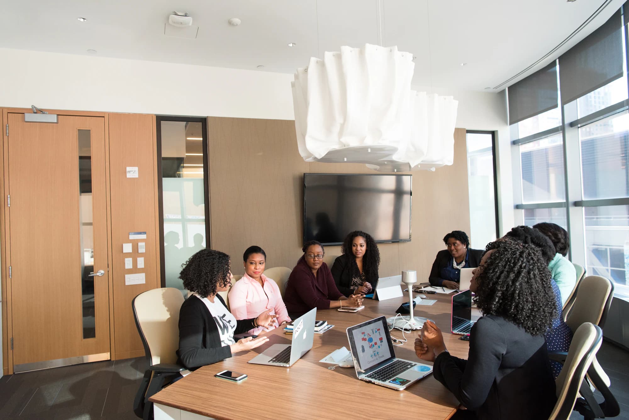 A small team seated around a long table in a bright office.