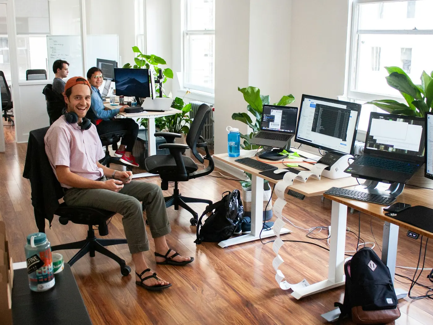A row of development desks with several monitors, code open on screen.