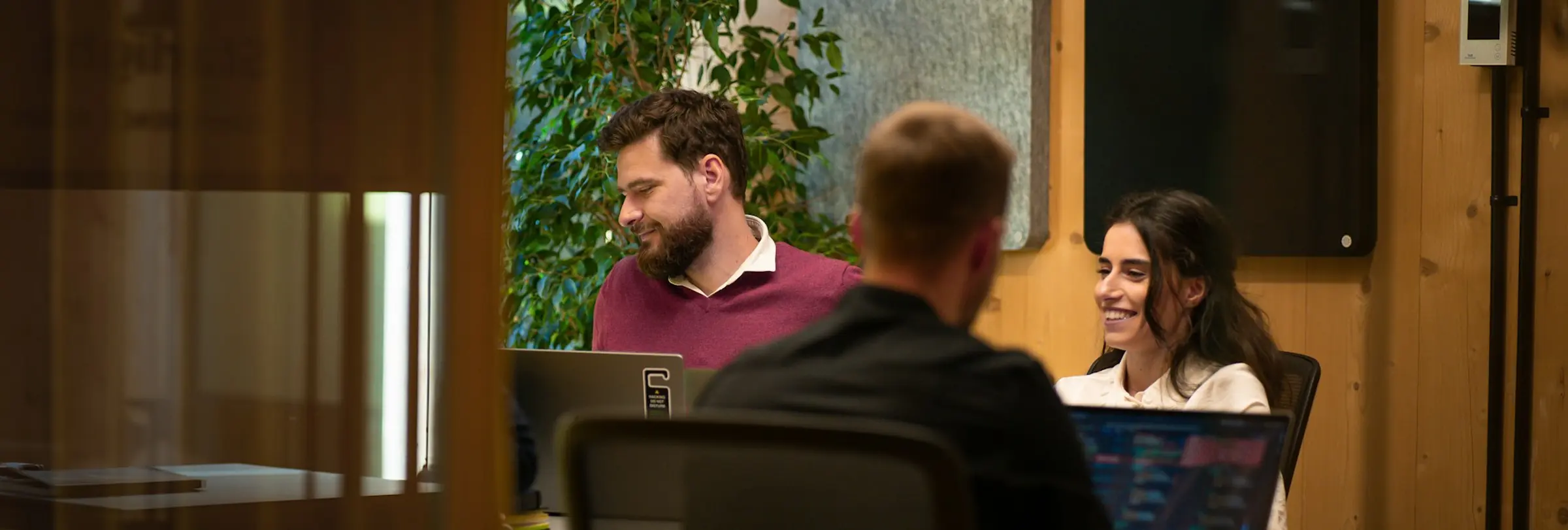 Three colleagues in a meeting room deciding which candidate to interview.