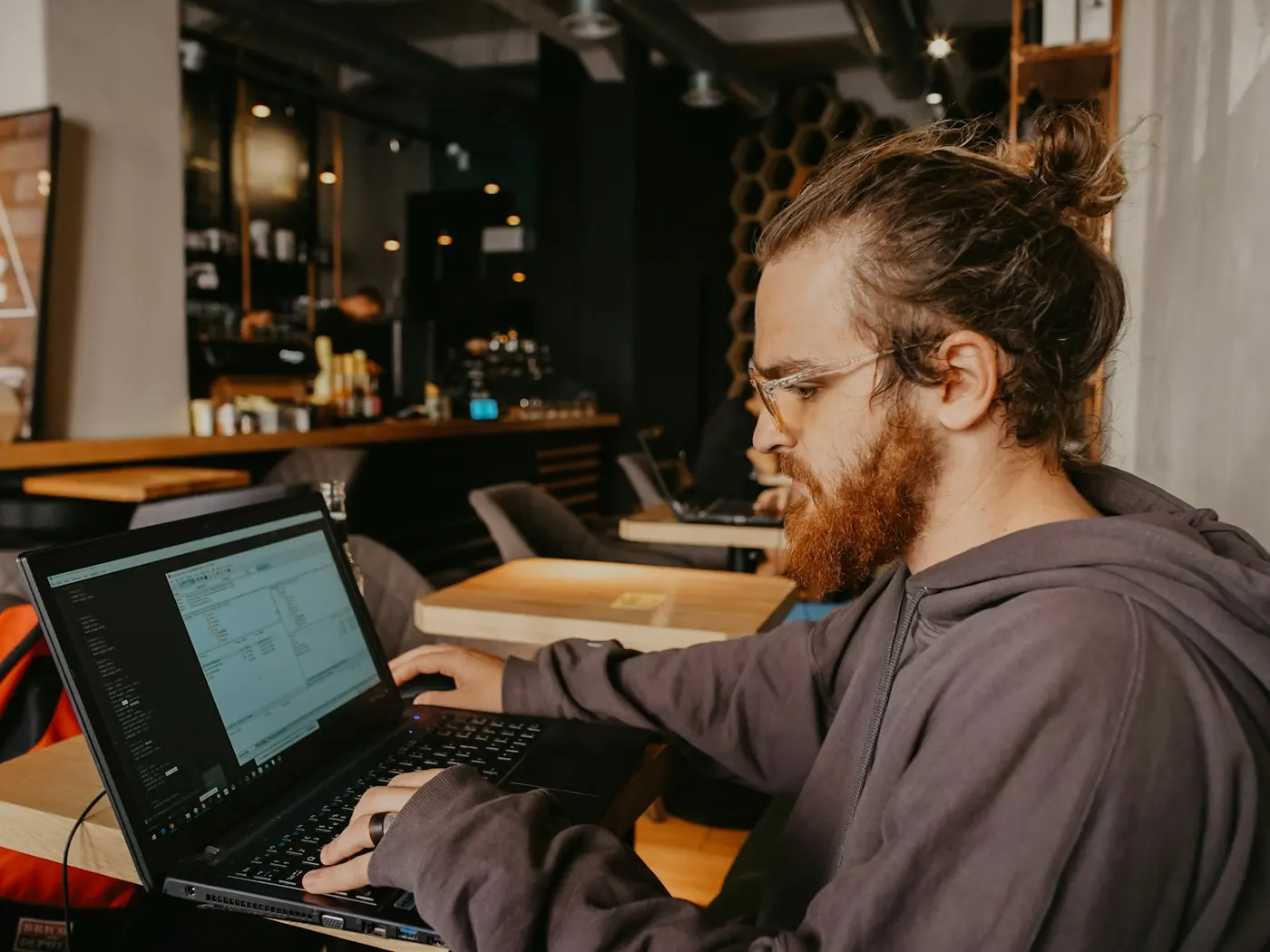 Someone reading a screen full of data, working alone in a busy room.